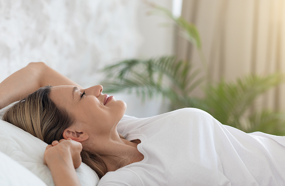 femme blonde bien reposee profitant d une matinee heureuse qui s etend au lit en souriant