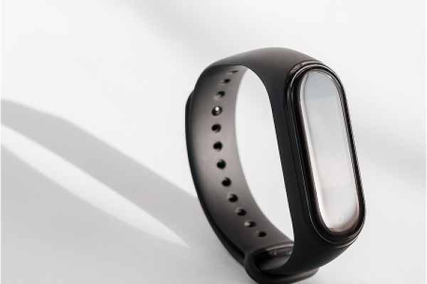 Montre connecté noir avec écran et bouton intégré sur fond clair avec ombre de la montre